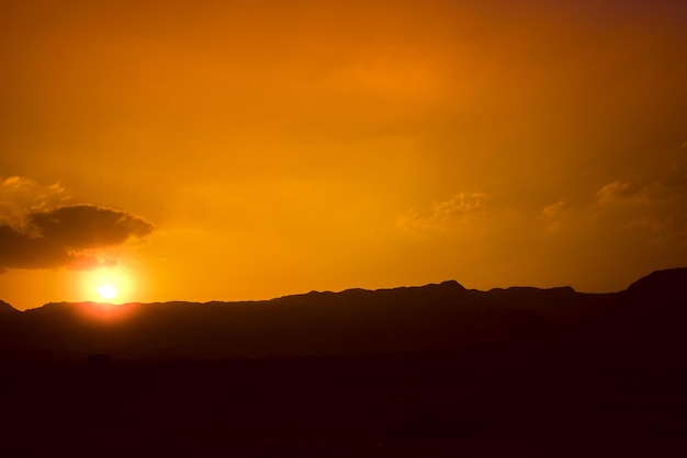 Desierto montañoso con un cielo anaranjado Desierto de Judea en Israel al atardecer