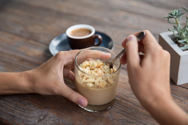 Desierto de panacotta con galleta en vidrio sobre fondo de mesa de madera