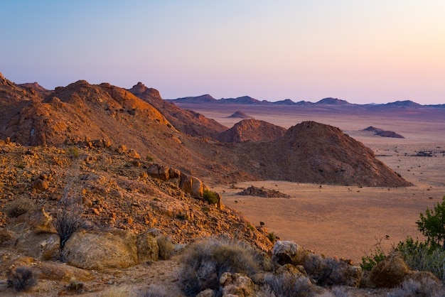 Desierto rocoso al atardecer, colorida puesta de sol sobre el desierto de Namib, Namibia, África