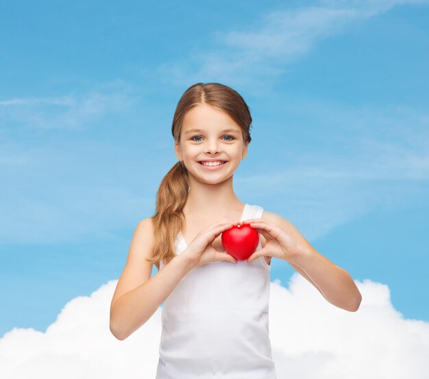 design de camisa, saúde, caridade, conceito de amor - adolescente sorridente na camisa branca em branco com pequeno coração vermelho