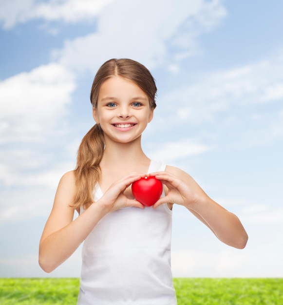 design de camisa, saúde, caridade, conceito de amor - adolescente sorridente na camisa branca em branco com pequeno coração vermelho