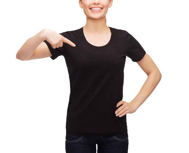 design de camiseta, conceito de pessoas felizes - mulher sorridente em camiseta preta em branco apontando o dedo para si mesma