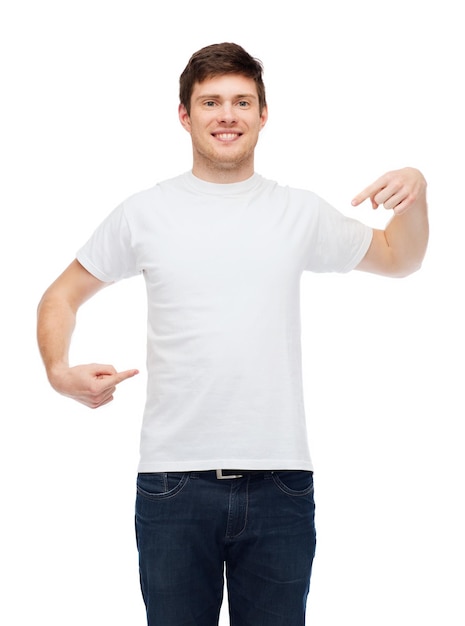 design de camiseta, gesto e conceito de pessoas - jovem sorridente em camiseta branca em branco apontando dedos em si mesmo