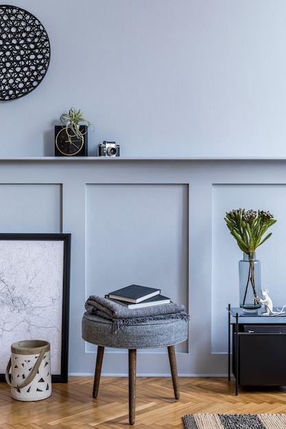 Design de interiores da sala de estar escandinava com mapa de pôster preto, banco cinza, mesa de centro preta, plantas, flores em um vaso, decoração, carpete, livro e acessórios pessoais elegantes.