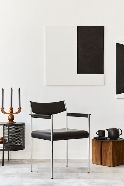 Design de interiores da sala de estar moderna com cômoda preta elegante, cadeira, pinturas de arte, lâmpada, livro, castiçal, decorações e acessórios elegantes na decoração da casa.