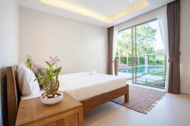 Design de interiores de luxo no quarto da villa piscina com cama king-size