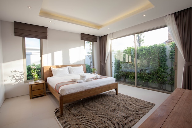 Design de interiores de luxo no quarto da villa piscina com cama king-size