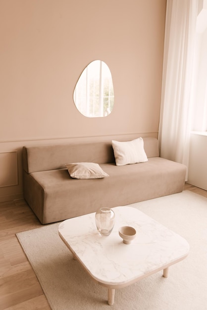 Design de interiores moderno Elegante sala de estar brilhante decorada com sofá confortável mesa de café flores pintando paredes brancas Apartamento minimalista para alugar