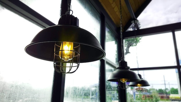 Design de interiores retrô antigo de decoração de lâmpada elétrica pendurada no teto em restaurante escuro Decoração clássica lâmpada de filamento incasdescente vintage em quarto escuro