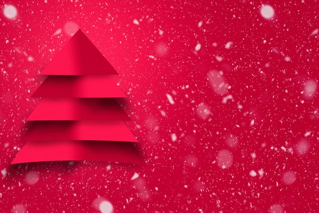 Design des roten Weihnachtsbaums mit Papierbeschaffenheit und schneebedecktem Hintergrund. Weihnachtskonzept.