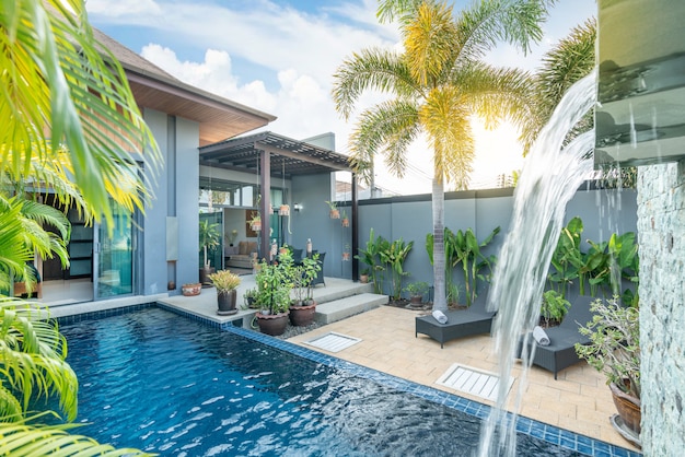 Design exterior e interior mostrando villa piscina tropical com jardim verde, com cama de sol e céu azul