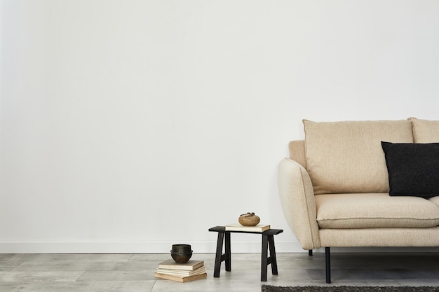 Design interior minimalista da sala de estar com sofá bege, mesinha lateral e acessórios modernos para a casa. Papel de parede. Copie o espaço. Modelo.