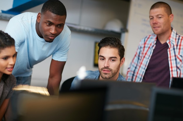 Foto design ist, was wir tun aufnahme eines teams von kollegen, die gemeinsam einen computer in einem modernen büro verwenden