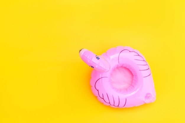 Design minimalista com flamingo inflável rosa isolado em amarelo