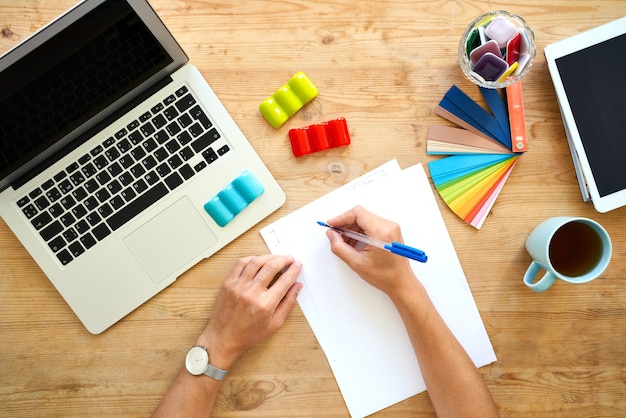 Designer-Arbeitsplatz, Draufsicht. Home Office - Schreibtisch mit Laptop, Zeiger mit buntem Set, Farbpalettenauswahl.