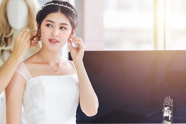 Designer asiático trabalhando na loja de moda de casamento