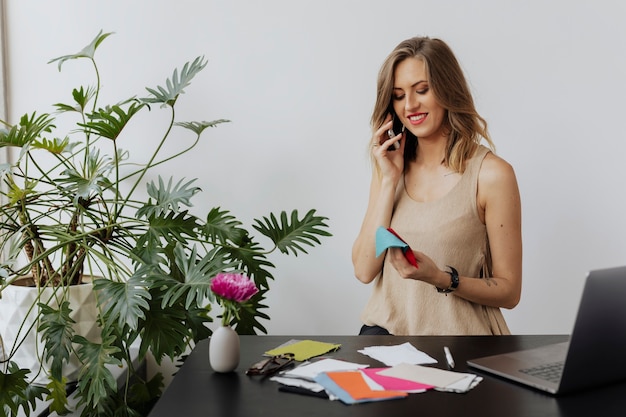 Designer de moda feminina falando ao telefone com o cliente