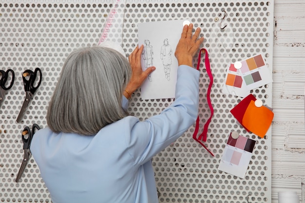 Foto designer de moda feminina no estúdio trabalhando em roupas