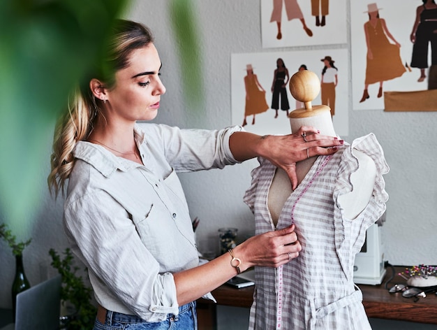 Designer de negócios sustentáveis de moda e mulheres com fita métrica de manequim e inicialização criativa concentre-se na criatividade e alfaiate com vestido em design ecológico de boneca em roupas em estúdio têxtil