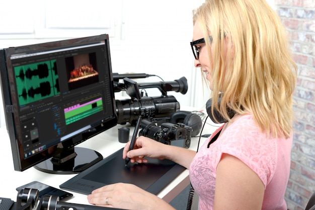 Designer der jungen Frau, der Computer für das Videobearbeiten verwendet