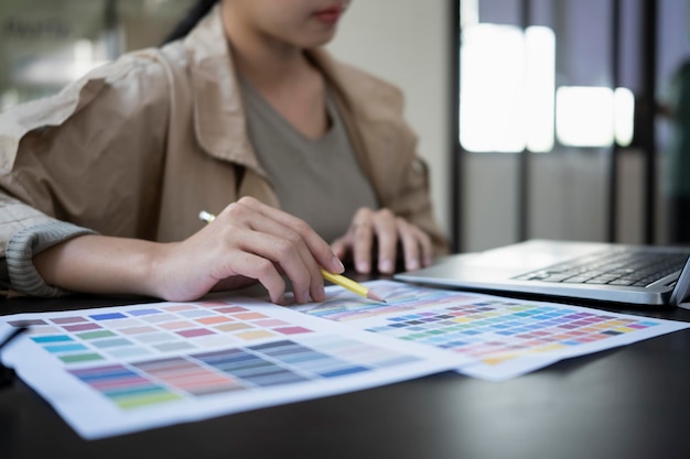 Foto designer gráfico feminino de tiro recortado escolhendo cores de amostra de cor.