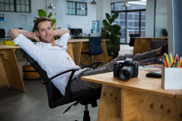 Foto designer gráfico masculino sorridente relaxante na cadeira