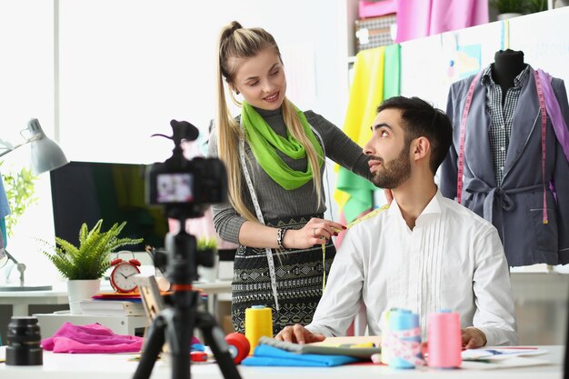 Designerin, die die Schulter ihres Kollegen vor der Kamera misst