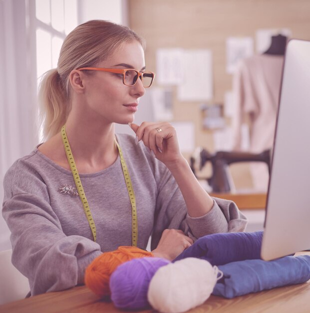 Foto designerin in der werkstatt mit blick auf den computerbildschirm