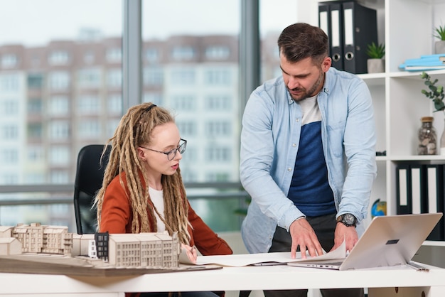 Designers criativos masculinos e femininos altamente qualificados, trabalhando com maquetes de futuros edifícios