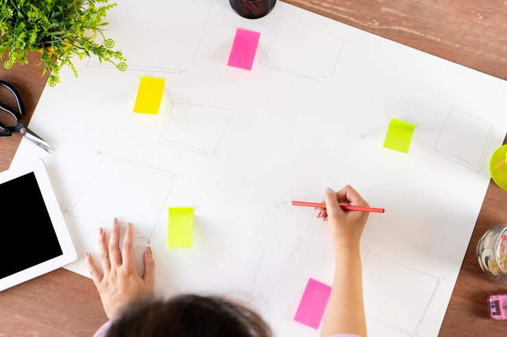 Designers de mulheres asiáticas estão usando lápis para projetar trabalhos em papel Vista superior