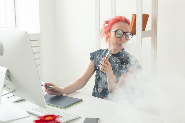 Designers gráficos criativos pessoas conceito jovem mulher criativa fumando um vape enquanto trabalha em um tablet gráfico