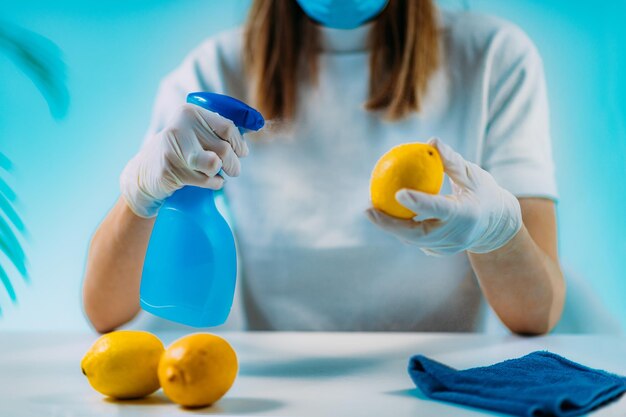 Foto desinfecção de frutas mulher desinfectando limão com lenços e desinfetante à base de álcool