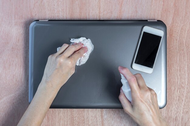 Foto desinfecção do computador com hidrogel na mesa de trabalho