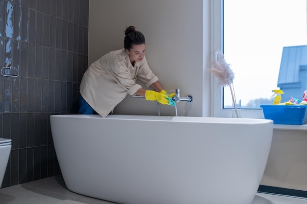 Desinfección. Un ama de casa desinfectando el baño en casa.