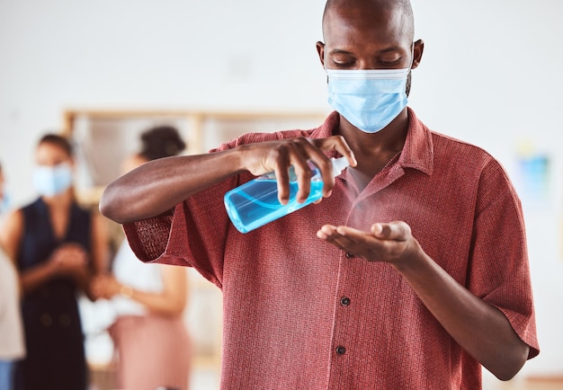 Desinfectante de manos covid y hombre de negocios con mascarilla en la reunión de negocios para la gestión y el cumplimiento de riesgos de seguridad sanitaria covid 19 corona virus y política hombre negro con limpieza de botellas de spray