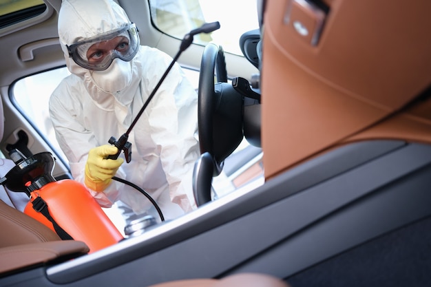 Desinfectante en traje de protección y gafas de tratamiento de coche con desinfectante