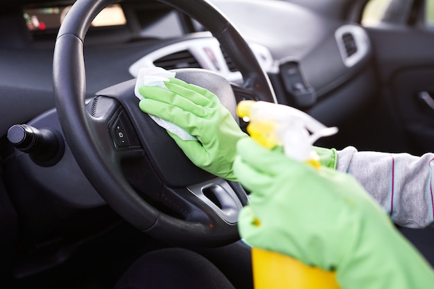 Desinfetante pulverizador manual feminino e toalhetes húmidos anti-sépticos para desinfecção de automóveis.