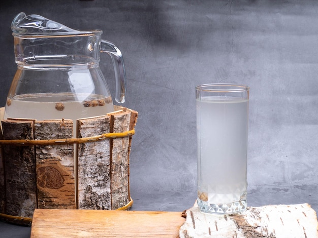 Desintoxicación de jugo natural de abedul en una jarra de vidrio sobre fondo de hormigón