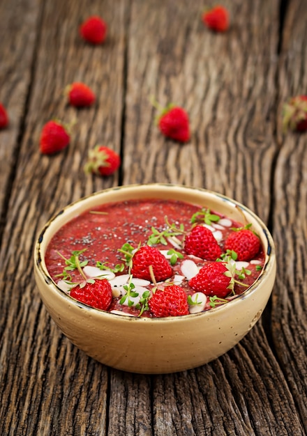 Desintoxicación y súper alimentos saludables desayuno en un tazón. Budín vegano de semillas de chía con fresas y almendras. Batido de fresas