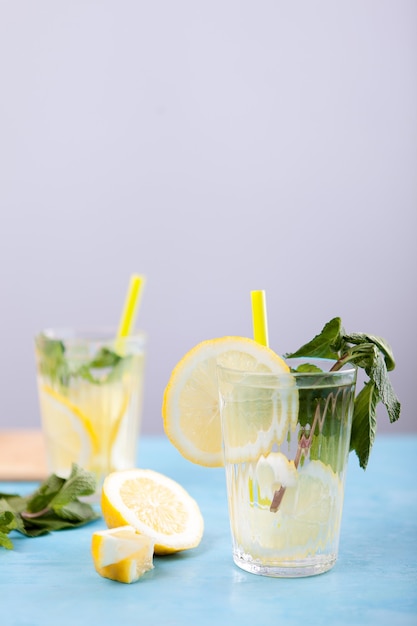 Foto desintoxique a água com limão em dois copos. limonada deliciosa caseira