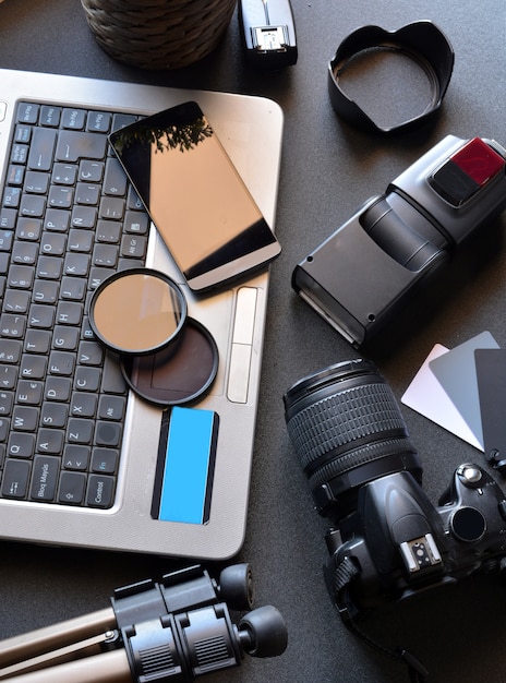 Desktop com equipamento fotográfico, câmera, tripé, flash e computador