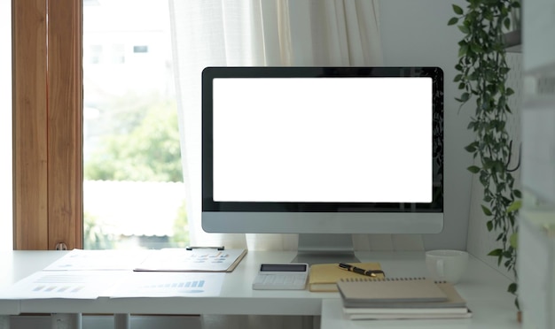 Desktop-Computer mit leerem Bildschirm in minimalem Büroraum mit Dekorationen und KopierraumxA