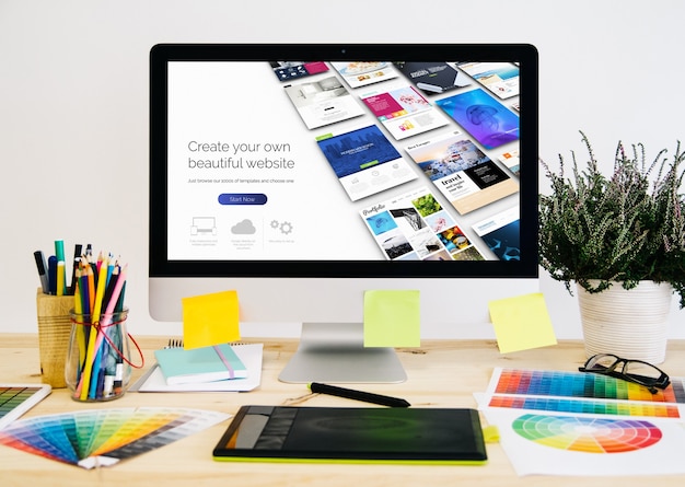 Foto desktop de papelaria com material de design, computador e tablet gráfico
