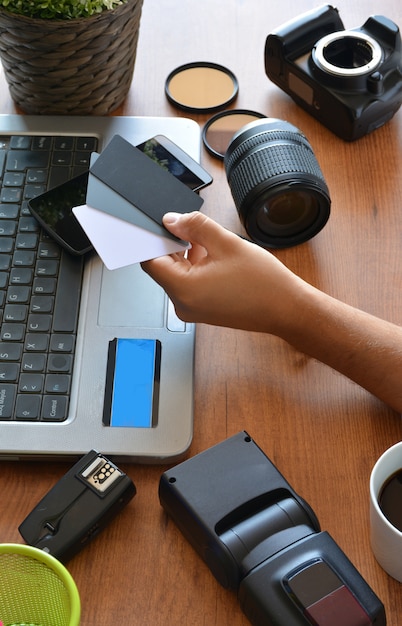 Desktop mit Fotoausrüstung, Kamera, Stativ, Blitz und Computer