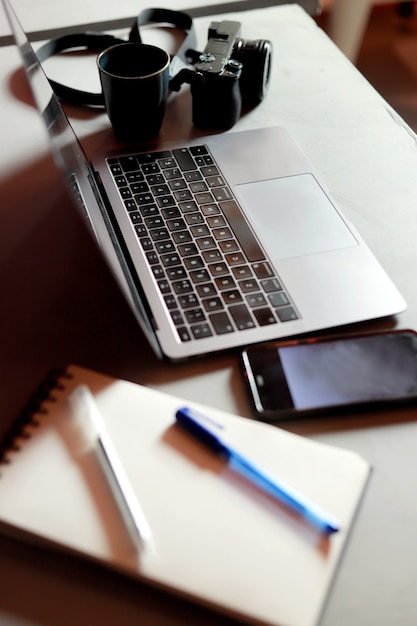 Desktop mit Laptop und mobiler und digitaler Kamera im Büro