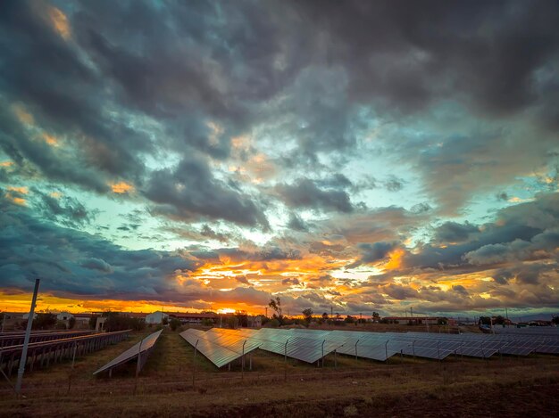 Deslumbrante céu colorido após o pôr do sol sobre painéis solares