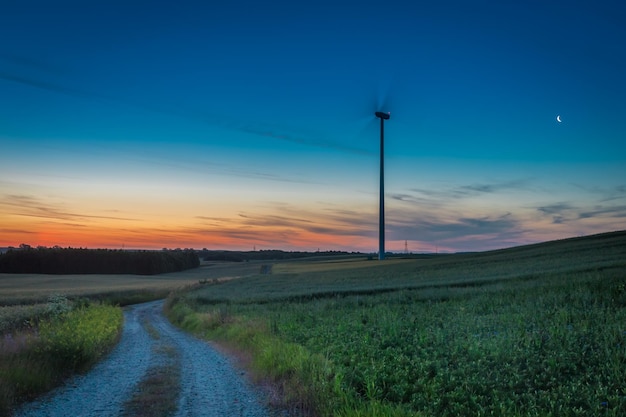 Deslumbrante crepúsculo sobre campo com turbinas eólicas