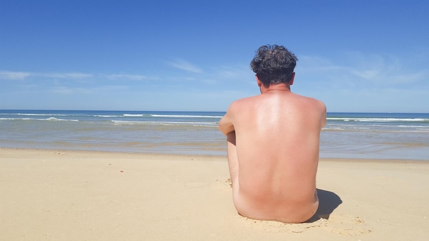 un, desnudo, hombre que sienta, en, playa, en, vacaciones