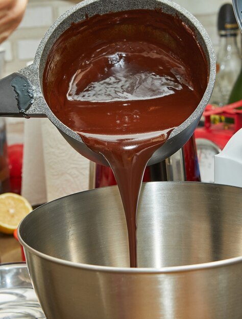 Despeje o chocolate fervido em uma tigela para misturar com nozes para cozinhar.