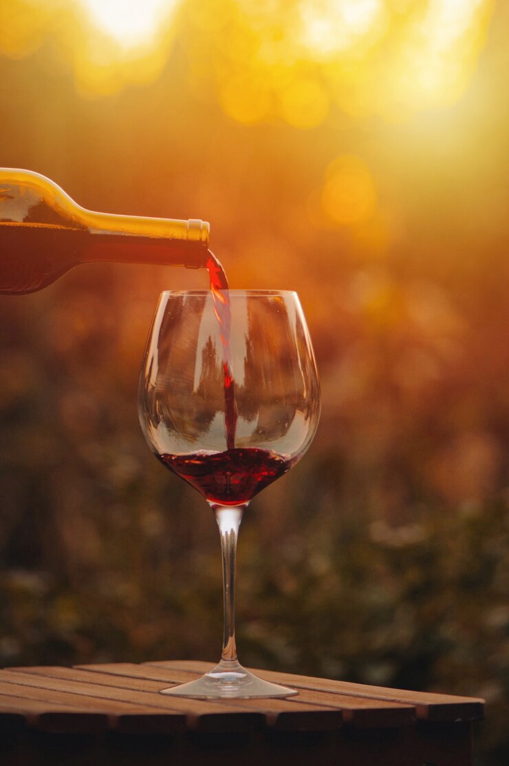 Despeje o vinho tinto. copo de vinho tinto na aldeia ao pôr do sol.